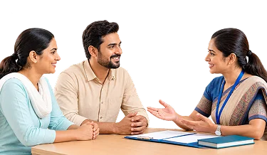 Two parents speaking with a JHPS admissions counsellor at a desk