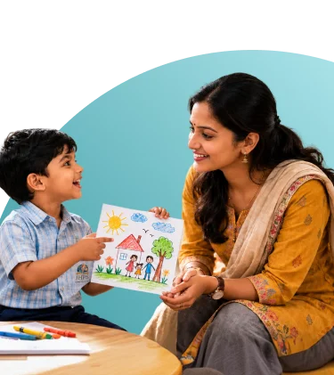 A JHPS teacher smiling at a young student showing his drawing of a house and family